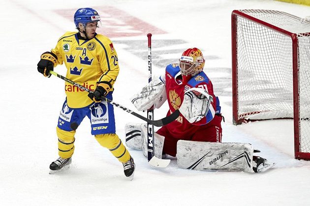 Švédský hokejista Andreas Wingerli v akci před ruským brankářem Alexandrem Samonovem během utkání na Švédských hokejových hrách.