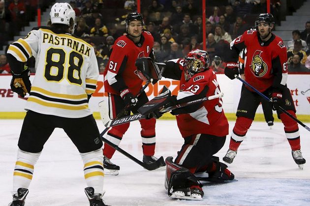 Český útočník David Pastrňák z týmu Boston Bruins sleduje situaci před brankou Ottawy v utkání NHL.