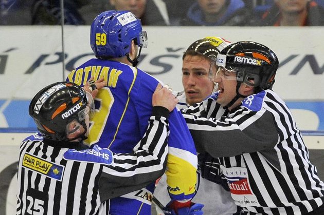 Rozhodčí Stanislav Barvíř (vlevo) a Petr Blümel zasahují u potyčky, v níž se střetli obránce Zlína Oldřich Kotvan a útočník Komety Jan Káňa.