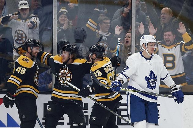 David Krejčí (vlevo), David Pastrňák a Brad Marchand (vpravo) oslavují branku, vstřelenou do sítě Toronta v zápase NHL.