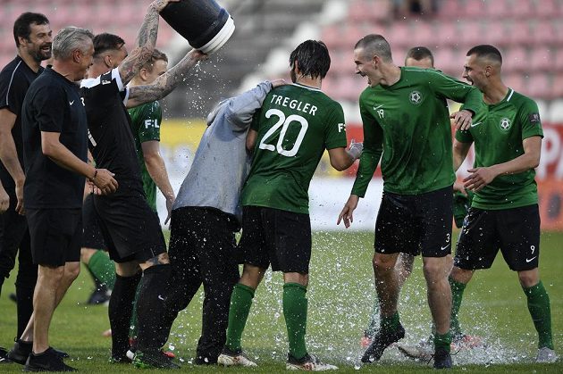Fotbalisté Příbrami se radují, po zápase, kdy udrželi nejvyšší soutěž, kropí vodou trenéra Romana Nádvorníka.
