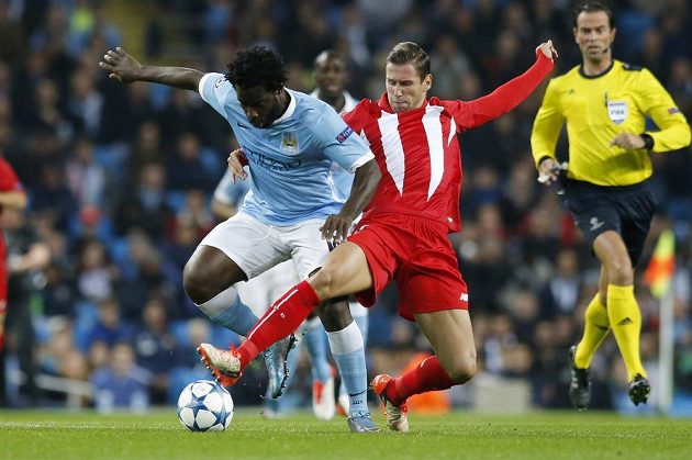 Wilfried Bony (vlevo) z Manchesteru City v tvrdém souboji s Grzegorzem Krychowiakem ze Sevilly.
