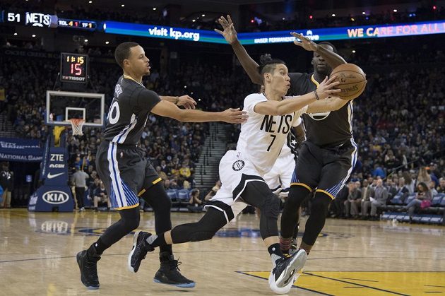 Jeremy Lin z Brooklynu v souboji s Válečníky Stephenem Currym a Draymondem Greenem během třetí čtvrtiny v Oracle Aréně.