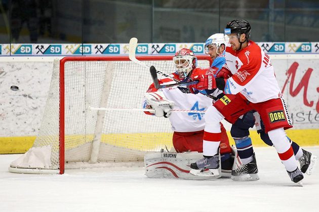 Olomoucký brankář Branislav Konrád, Jakub Sklenář z Chomutova a Jan Jaroměřský z Olomouce sledují, jak puk míjí branku Hanáků v utkání 27. kola extraligy.