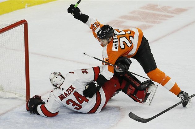 Útočník Philadelphie Flyers James van Riemsdyk (25) narazil do brankáře Caroliny Hurricanes Petra Mrázka.