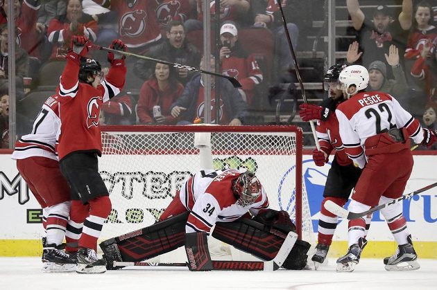 Radost New Jersey Devils. Nico Hischier, druhý zleva, slaví, protože připravil gól pro Marcuse Johanssona v utkání s Carolinou. Brankář Petr Mrázek byl bezmocný.