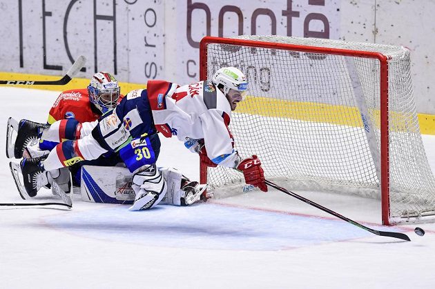 Brankář Českých Budějovic Petr Kváča sleduje, jak pardubický hokejista Brian Ihnačák naloží se svým zakončením v utkání baráže o extraligu.