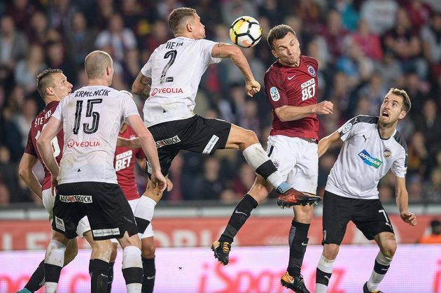 Plzeňský Lukáš Hejda (č.2) a David Lafata ze Sparty Praha ve vzdušném souboji v duelu 10. kola. Plzeňský zadák zasahuje míč rukou.