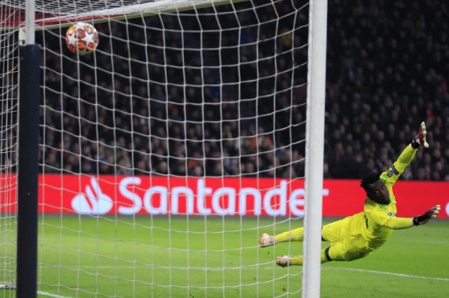 Gólman Ajaxu Andre Onana se marně snaží zasáhnout proti ráně Karima Benzemy v utkání Ligy mistrů.