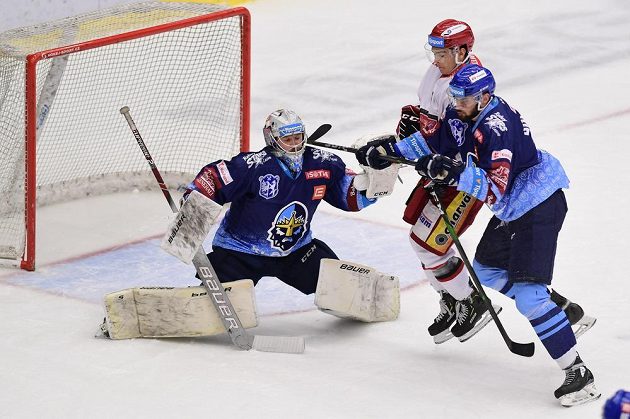 Brankář Denis Godla a Ladislav Romančík z Kladna a Jordann Perret z Hradce Králové (uprostřed) v akci během extraligového utkání.