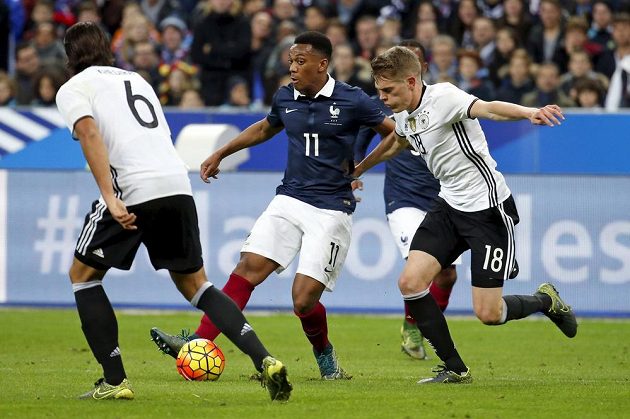 Francouzský útočník Anthony Martial (uprostřed) v obležení dvou německých soupeřů během přátelského utkání.