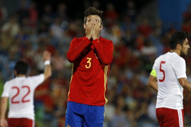 Zatímco obránce Španělska Gerard Piqué si schovává tvář v dlaních, za ním slaví hráči Gruzie historické vítězství.