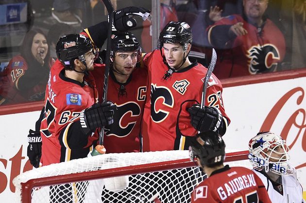 Hokejisté Calgary Mark Giordano (5), Michael Frolík (67) a Sean Monahan (23) se radují z gólu proti Washingtonu, jemuž ale podlehli vysoko 2:6.