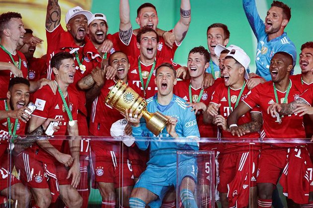 Brankář Manuel Neuer (uprostřed s trofejí) oslavuje se spoluhráči z Bayernu Mnichov triumf v Německém poháru.