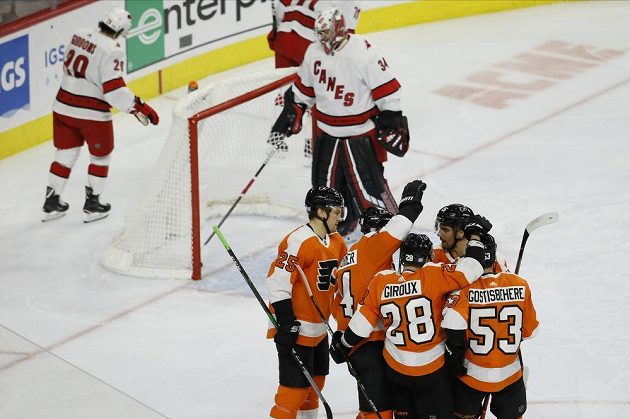 Hokejista Philadelphia Flyers Sean Couturier (14) slaví se spoluhráči gól, který vstřelil Petru Mrázkovi z Caroliny Hurricanes.