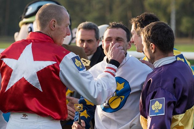 Marek Stromský (uprostřed) přijímá gratulace soupeřů po vítězství ve Velké pardubické.