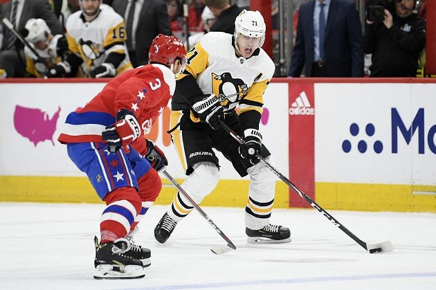 Hvězdný útočníku Pittsburghu Penguins Jevgenij Malkin (71) během utkání NHL proti Washingtonu odehrává puk před dotírajícím obráncem Nickem Jensenem (3).