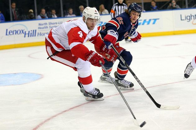 Zadák Detroitu Red Wings Jakub Kindl (4) bojuje o kotouč s levým křídlem New Yorku Rangers Carlem Hagelinem.