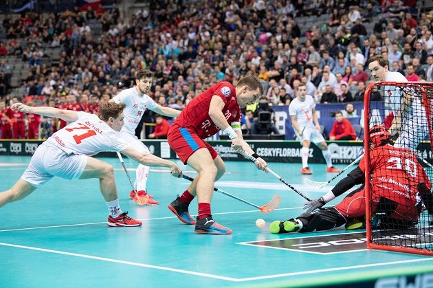 Matěj Jendřišák (uprostřed) a Tobias Heller ze Švýcarska během utkání v základní skupině Mistrovství světa ve florbale