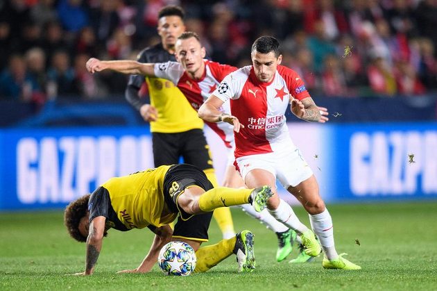 Axel Witsel z Dortmundu kouzlí na zemi s míčem a dotírající Nicolae Stanciu ze Slavie Praha během utkání základní skupiny Ligy mistrů v Praze.