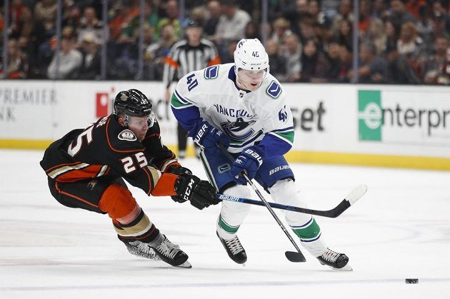 Český útočník Ondřej Kaše z Anaheimu se snaží zastavit Eliase Petterssona z Vancouveru v utkání NHL.
