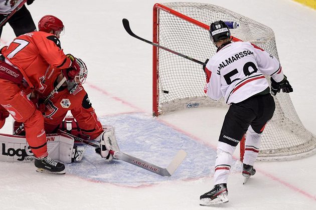 Hokejista Simon Hjalmarsson z Frölundy (vpravo) střílí gól. Zleva přihlížejí Richard Nedomlel a brankář Marek Mazanec, oba z Hradce Králové.