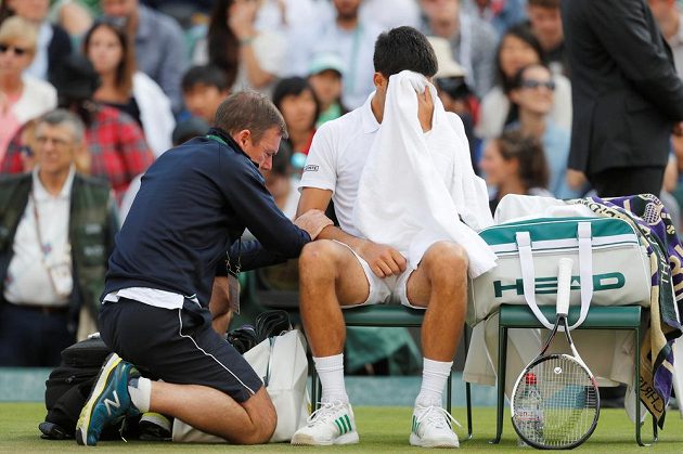Srb Novak Djokovič v péči fyzioterapeuta při čtvrtfinále s Tomášek Berdychem.