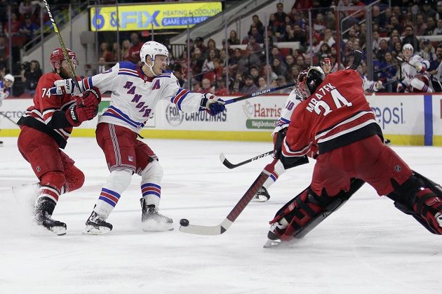 Český gólman Caroliny Hurricanes Petr Mrázek (34) rozehrává puk během utkání NHL.