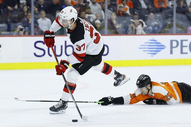 Pavel Zacha z New Jersey střílí, James van Riemsdyk z Philadelphie už českého útočníka nestihl zastavit.