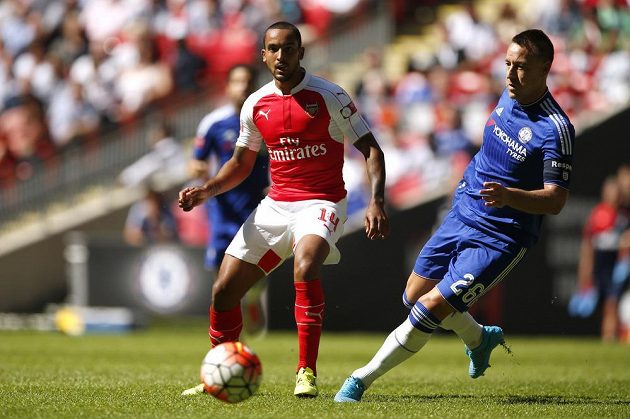 Útočník Arsenalu Theo Walcott (vlevo) přihrává před obráncem Chelsea Johnem Terrym Alexi Oxlade-Chamberlainovi do gólové šance.