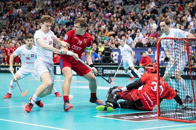 Matěj Jendřišák (uprostřed) a Tobias Heller ze Švýcarska během utkání v základní skupině Mistrovství světa ve florbale