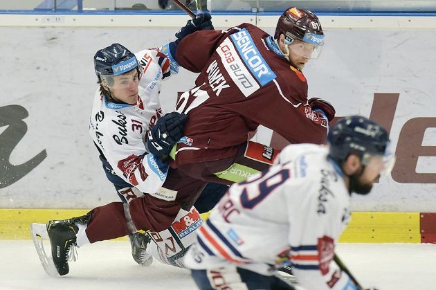 Hokejista Lukáš Klimek ze Sparty v utkání předkola play off proniká mezi dvojicí vítkovických hráčů Tomášem Gumanem a Romanem Szturcem.
