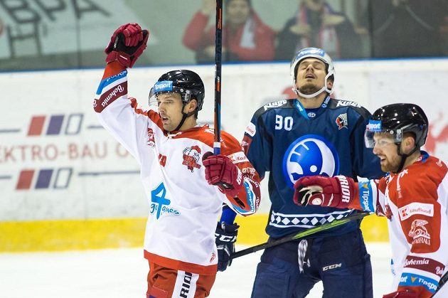 Olomoucký hokejista Lukáš Nahodil se raduje, zklamaný Roman Vráblík z Plzně všemu během extraligového utkání jen přihlíží.