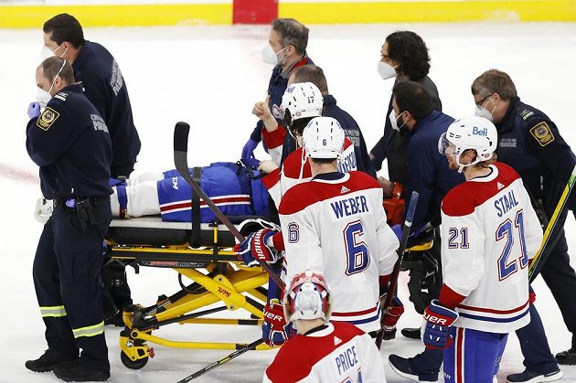 Útočník Montrealu Canadiens Jake Evans (71) skončil po hrubém ataku v utkání play off NHL na nosítkách, zdviženým palcem ale ukázal fanouškům, že bude v pořádku.