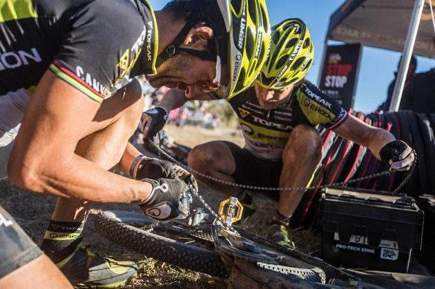Kristián Hynek (vpravo) a Alban Lakata opravují přetržený řetěz při páteční etapě Cape Epic.