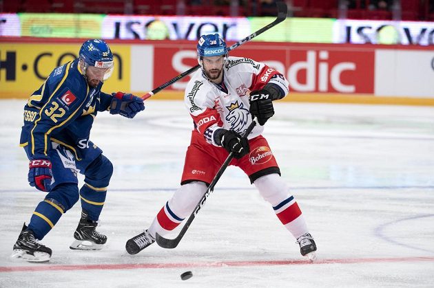 Český forvard Tomáš Hyka nahazuje puk do útočné třetiny, vlevo sleduje jeho počínání Lukas Bengtsson ze Švédska.