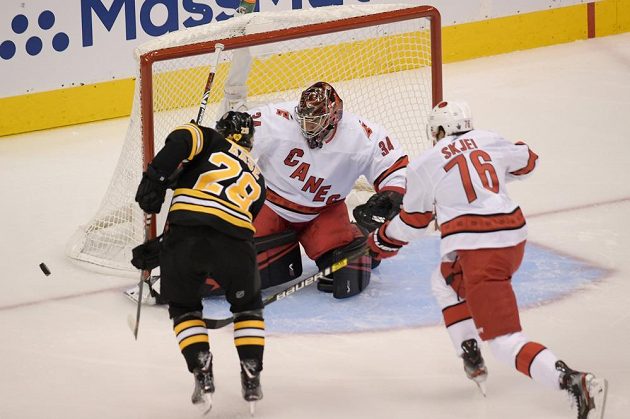 Gólman Caroliny Petr Mrázek (34) kryje střelu Ondřeje Kašeho z Bostonu v 1. kole Stanley Cupu.