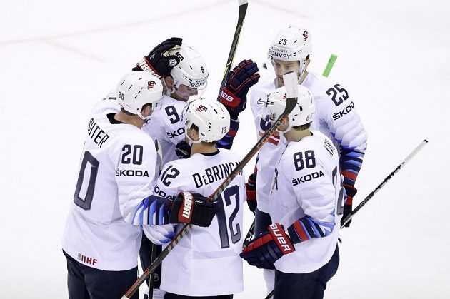 Americký hokejový reprezentant Alex DeBrincat slaví se spoluhráči gól, který vstřelil na mistrovství světa do sítě Slovenska.
