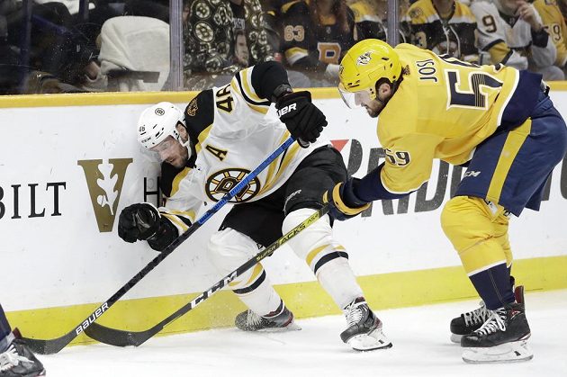 Český útočník Bostonu David Krejčí čelí ataku Romana Josiho z Nashville Predators v utkání NHL.