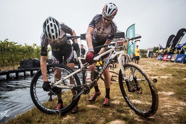 Jaroslav Kulhavý (vpravo) a Christoph Sauser z týmu Songo Specialized řeší problém s defektem při Cape Epic 2015.