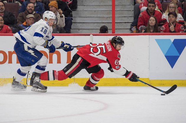 Český útočník Ondřej Palát z Tampy Bay se snaží atakovat unikajícího obránce Ottawy Senators Erika Karlssona v utkání NHL s Ottawou Senators. Palát gól nedal, ale měl asistenci u vítězné trefy svého týmu.