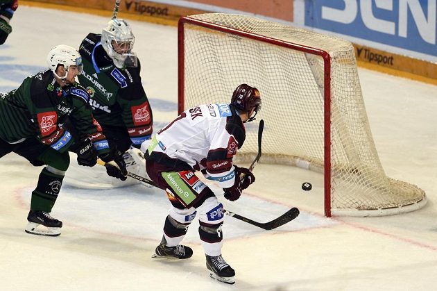 Lukáš Rousek (vpravo) ze Sparty střílí gól do odkryté branky Karlových Varů. Přihlížejí karlovarský gólman Jan Bednář a jeho spoluhráč Tomáš Knotek.