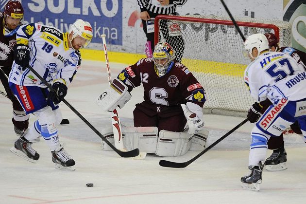 Útočníci Komety Libor Pivko (vlevo) a Jan Hruška (vpravo) před sparťanským brankářem Tomášem Pöpperlem.