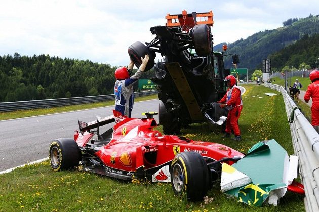 Organizátoři odklízí monopost Fernanda Alonsa, který přistál na ferrari Kimiho Räikkönena.