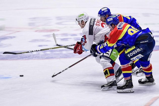 Pardubický hokejista Petr Sýkora se snaží prosadit v utkání baráže i extraligu. zastavit se jej snaží René Vydarený a Ondřej Kachyňa z Budějovic.