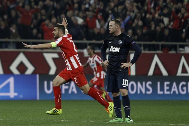 Giannis Maniatis (vlevo), kapitán Olympiakosu, jásá po gólu v síti Manchesteru United. Vpravo rozčarovaný Wayne Rooney.