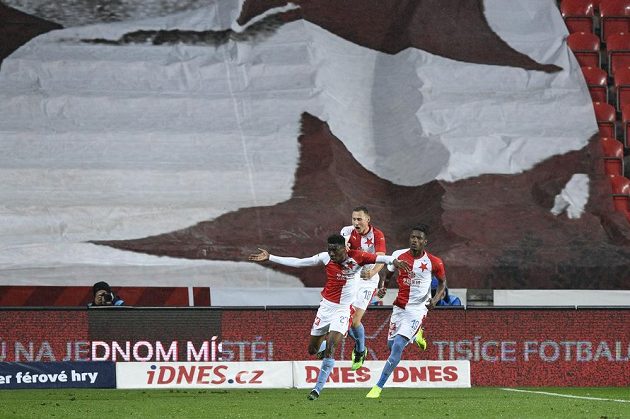 Hráči Slavie (zprava) Simon Deli a Jan Bořil se před prázdnou tribunou Sever radují z prvního gólu, který dal Ibrahim Traoré (vpředu).