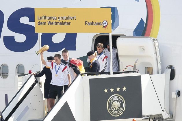Kapitán Philipp Lahm s trofejí jako první opustil letadlo. Za ním Bastian Schweinsteiger.