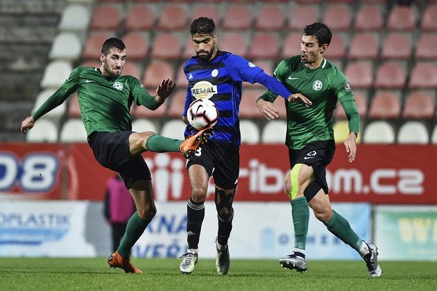 Fotbalista Jusúf Hilál z Bohemians mezi příbramskými hráči Karlem Soldátem (vlevo) a Markem Kodrem během pohárového zápasu.