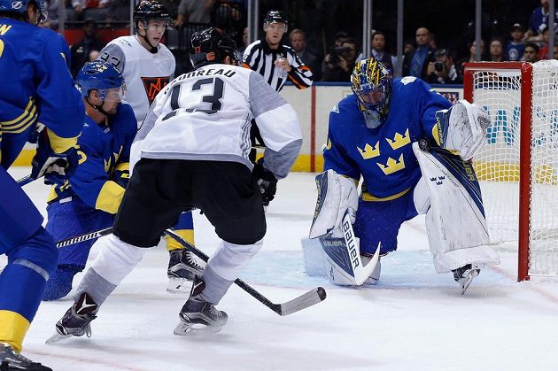 Švédský brankář Henrik Lundqvist (30) při zásahu proti Johnny Gaudreauovi (13) v utkání Světového poháru.